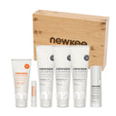 Die Premium Box von newkee enthält Sonnenschutz, Hautpflege und Reinigung in einer hochwertigen Holzbox.